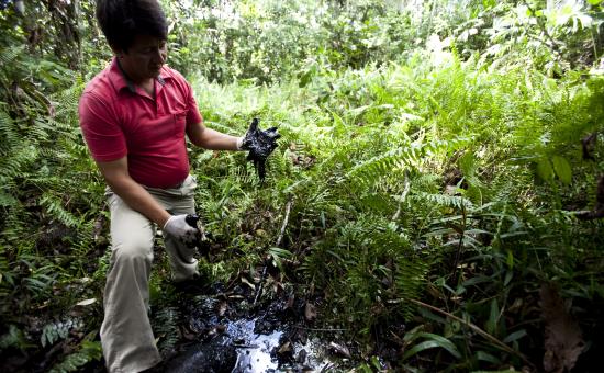 Man shows the crude oil abandoned by Texaco which contaminates the Ecuadorian Amazon