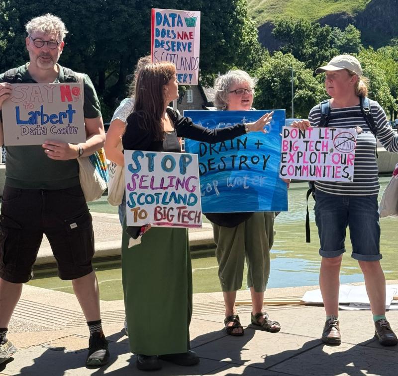 4 protesters opposing the Larbert data centre development hold placards outside the Scottish parliament