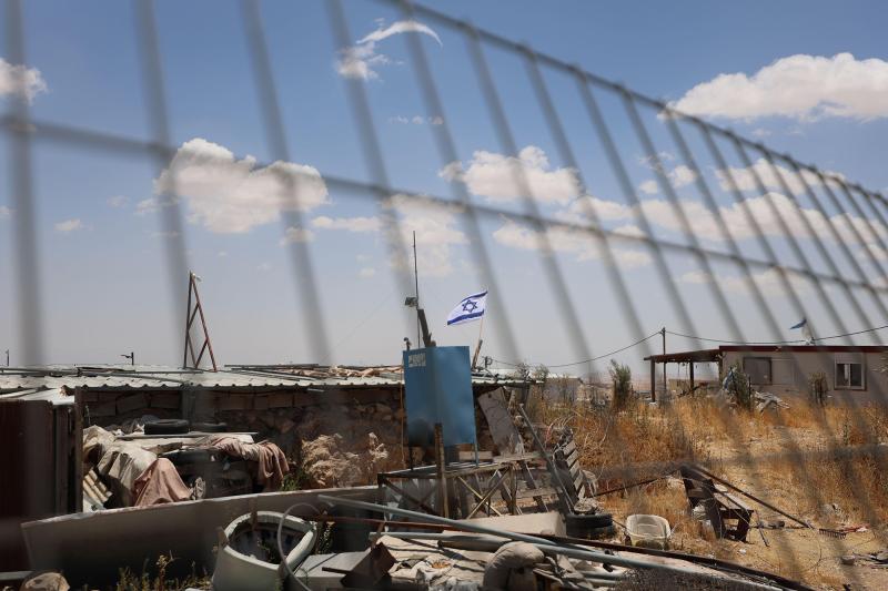 An Israeli flag behind a metal fence