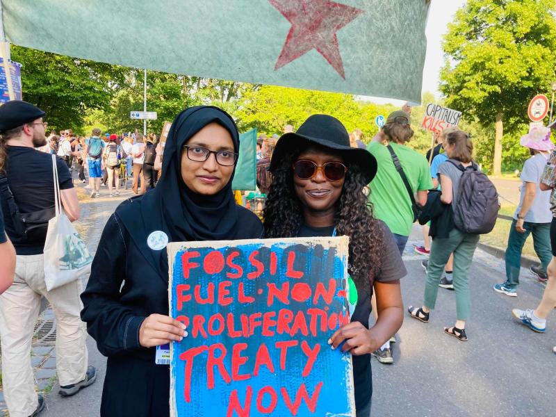 photo of two people holding a placard which reads 'fossil fuel non proliferation treaty'