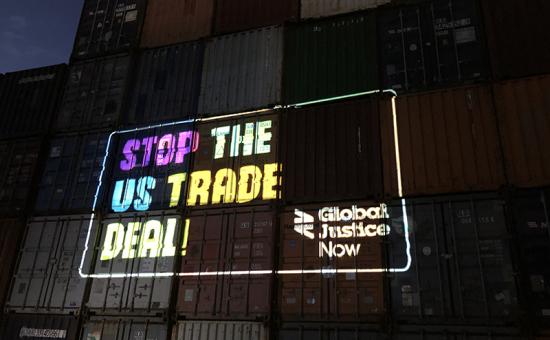 Projection of 'Stop the US trade deal' onto shipping containers